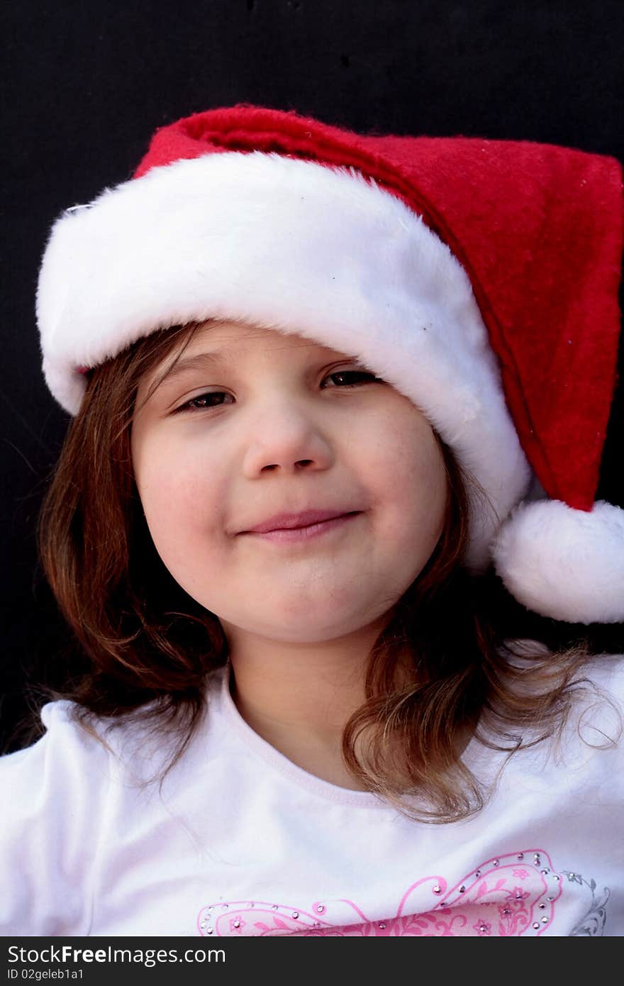 Little girl with red Santa hat on, smiling and happy. Little girl with red Santa hat on, smiling and happy