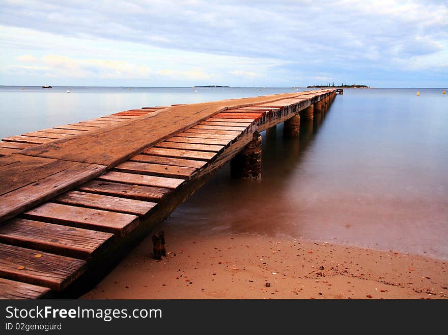 Beautiful view of New Caledonia. Wooden dock at Anse Vata beach Noumea, New Caledonia. Beautiful view of New Caledonia. Wooden dock at Anse Vata beach Noumea, New Caledonia