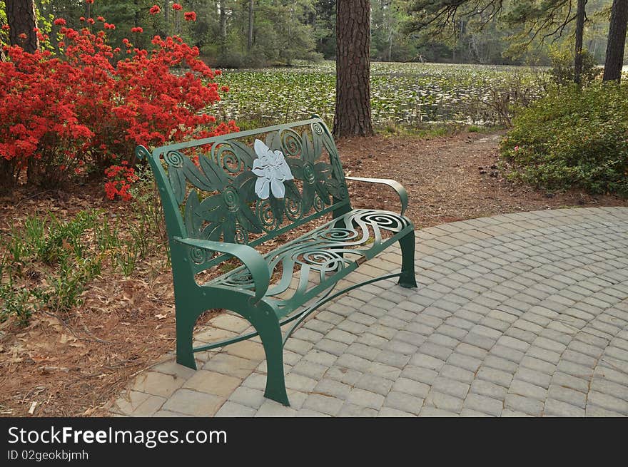 A garden bench with azalea flowers