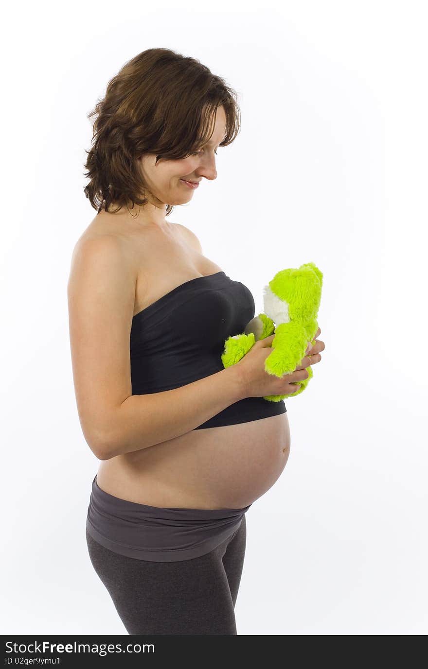 Beautiful young pregnant woman with green frog toy. Beautiful young pregnant woman with green frog toy