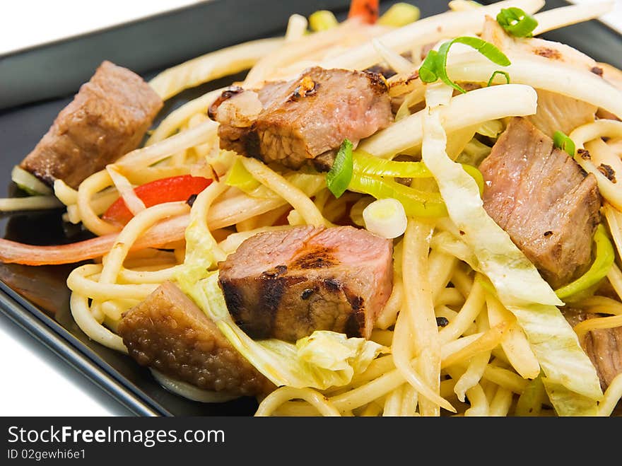 Noodles and three kinds of meat on black plate