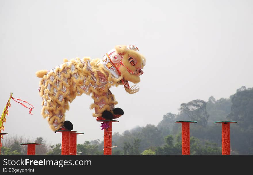 A chinese lion dance on high iron pole.