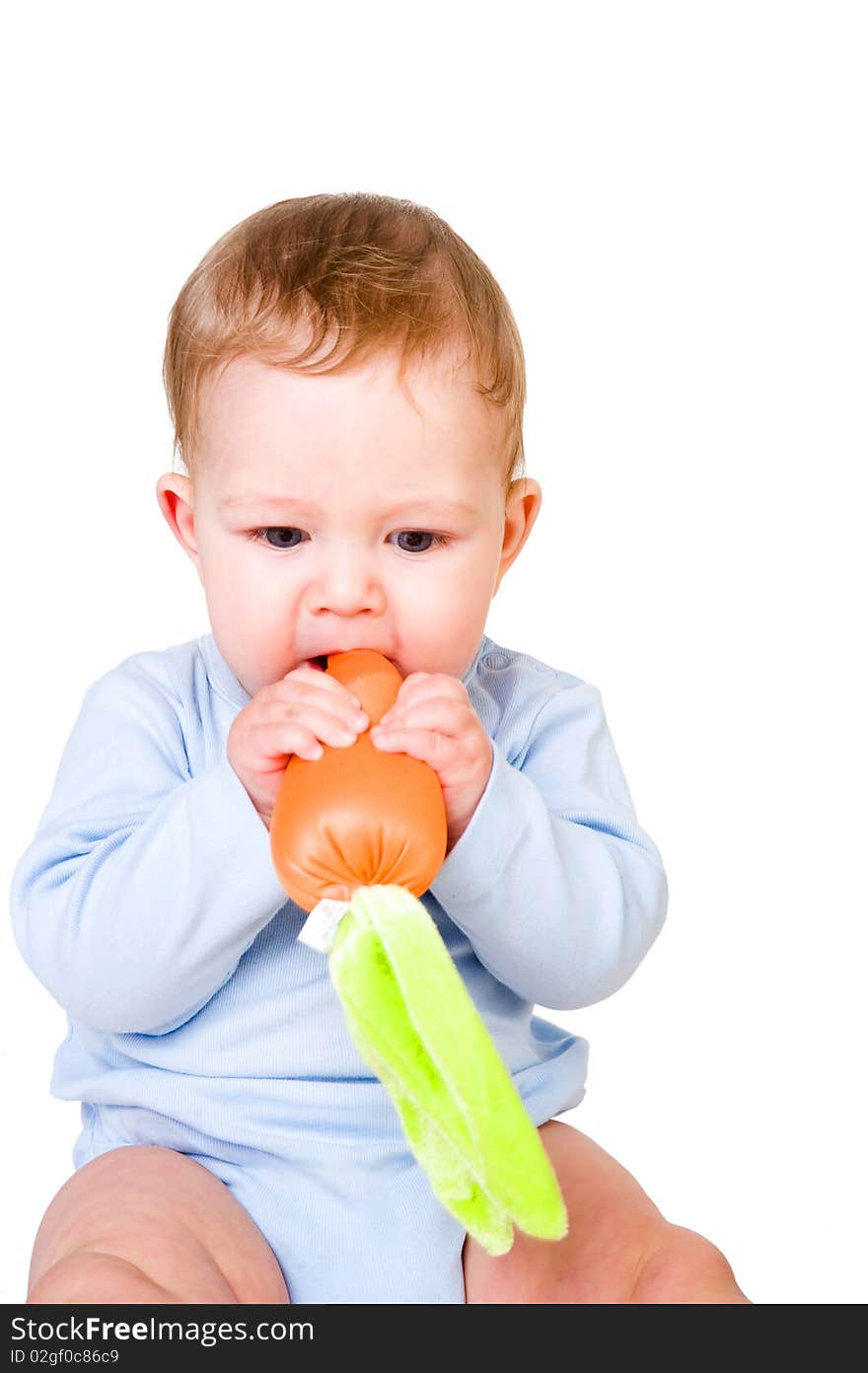 Baby boy eating toy carrot. Baby boy eating toy carrot