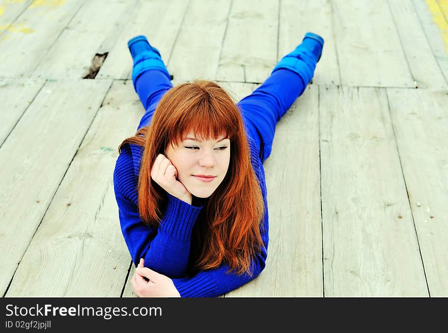 Cunning redheaded ten girl laying on the pier. Cunning redheaded ten girl laying on the pier