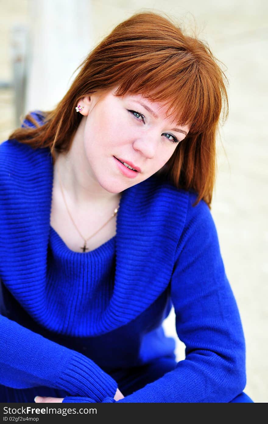 Bright redheaded beauty teen girl wearing blue sweater