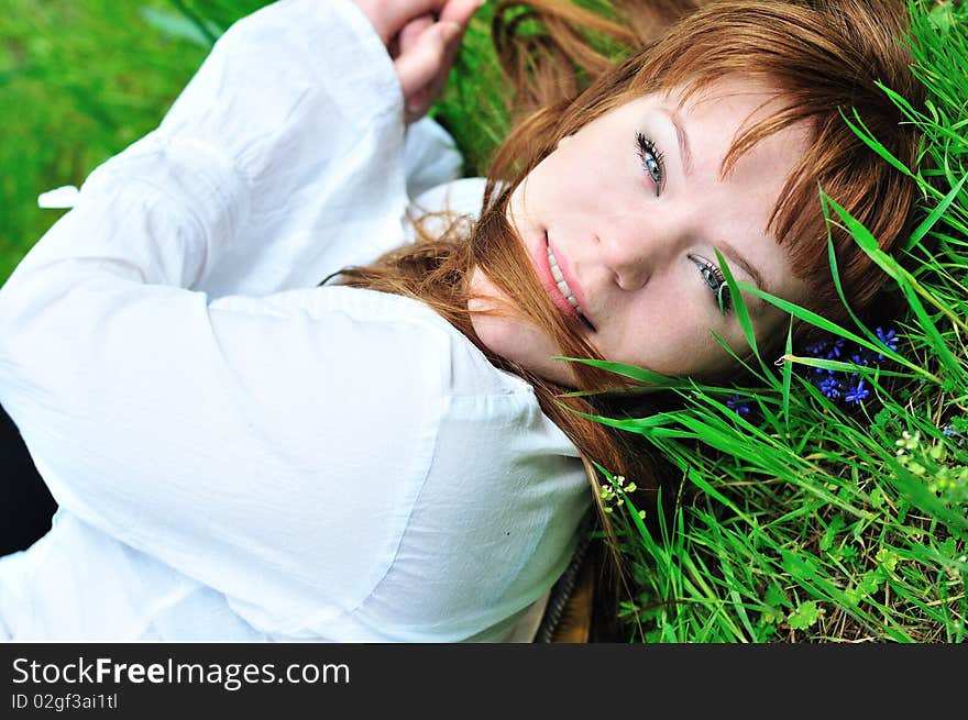 Redheaded girl laying on the spring meadow. Redheaded girl laying on the spring meadow