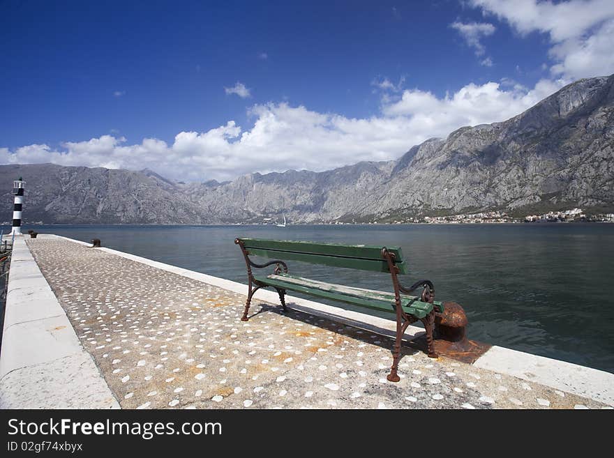 A green public bench facing out over Kotor Bay, Montenegro. A green public bench facing out over Kotor Bay, Montenegro