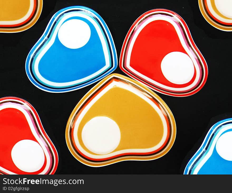 A background of colored heart shaped designer saucers. A background of colored heart shaped designer saucers