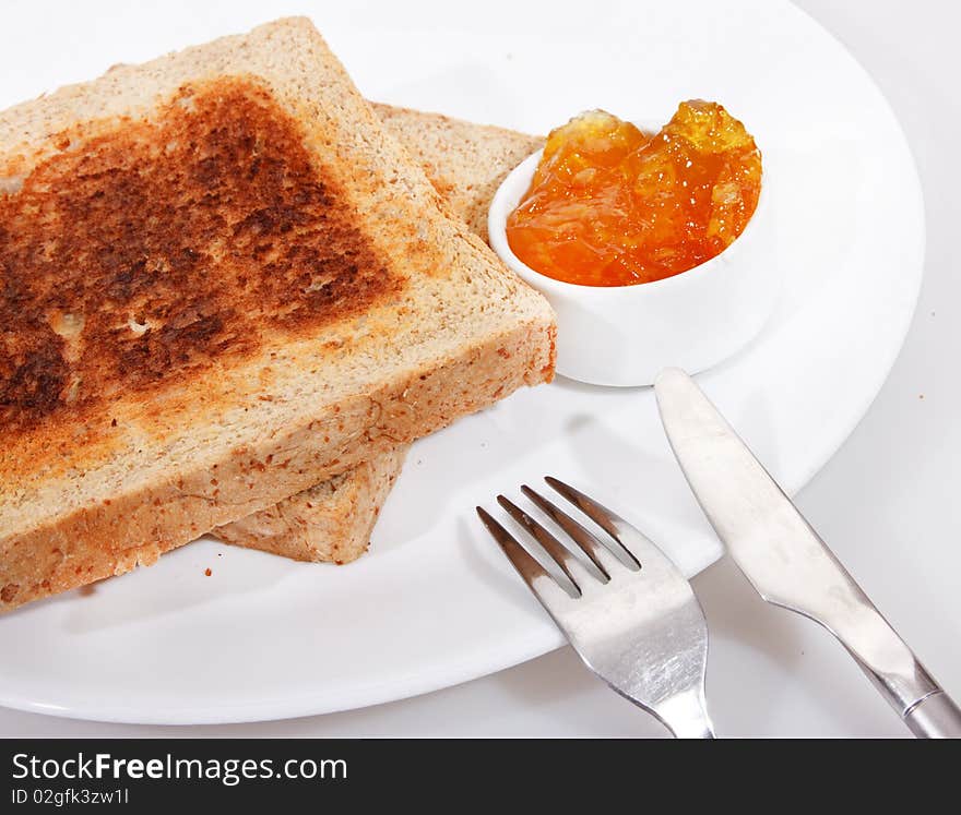 Studio shot of toasted wholewheat bread and sweet orange jam