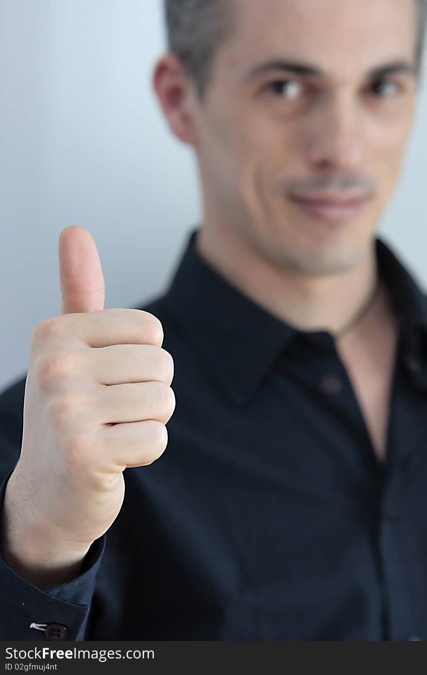 Man with the thumb pointing upwards as a sign of success