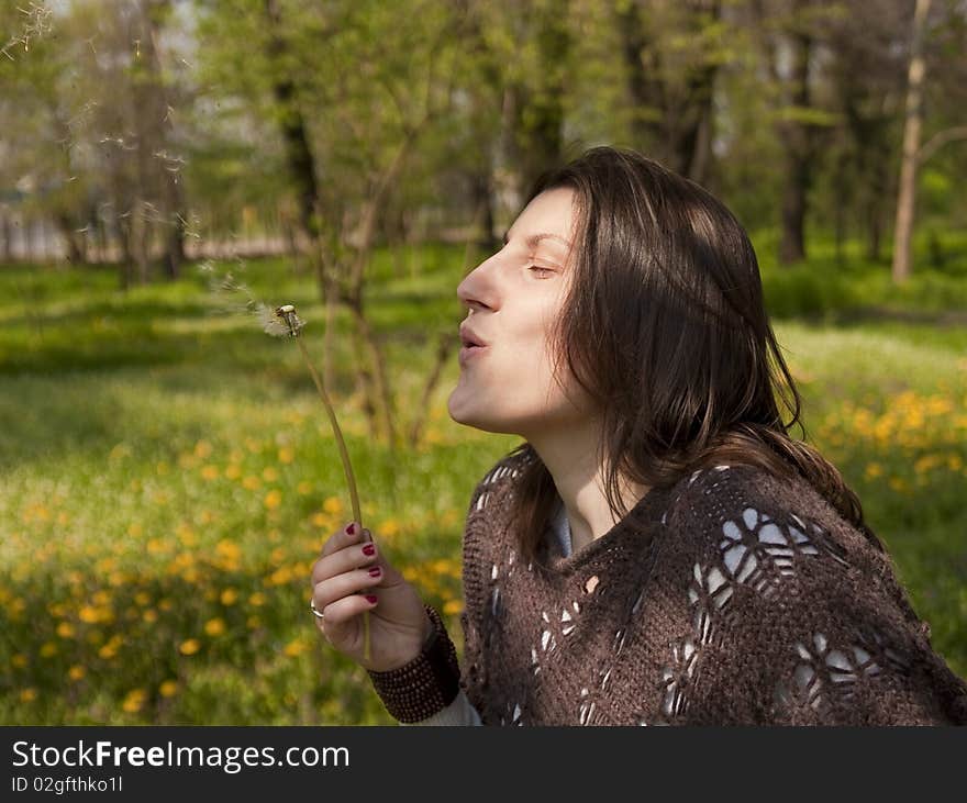 Beautiful woman blowing dandelion