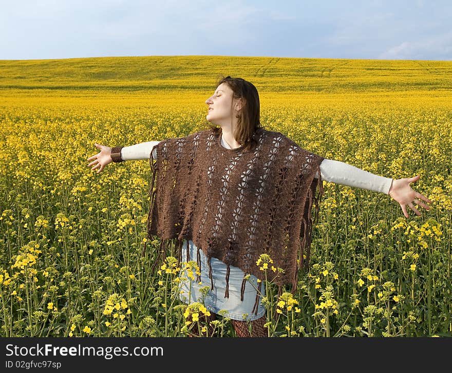 Young girl standing in sunny field with yellow flowers and blue sky. Young girl standing in sunny field with yellow flowers and blue sky.