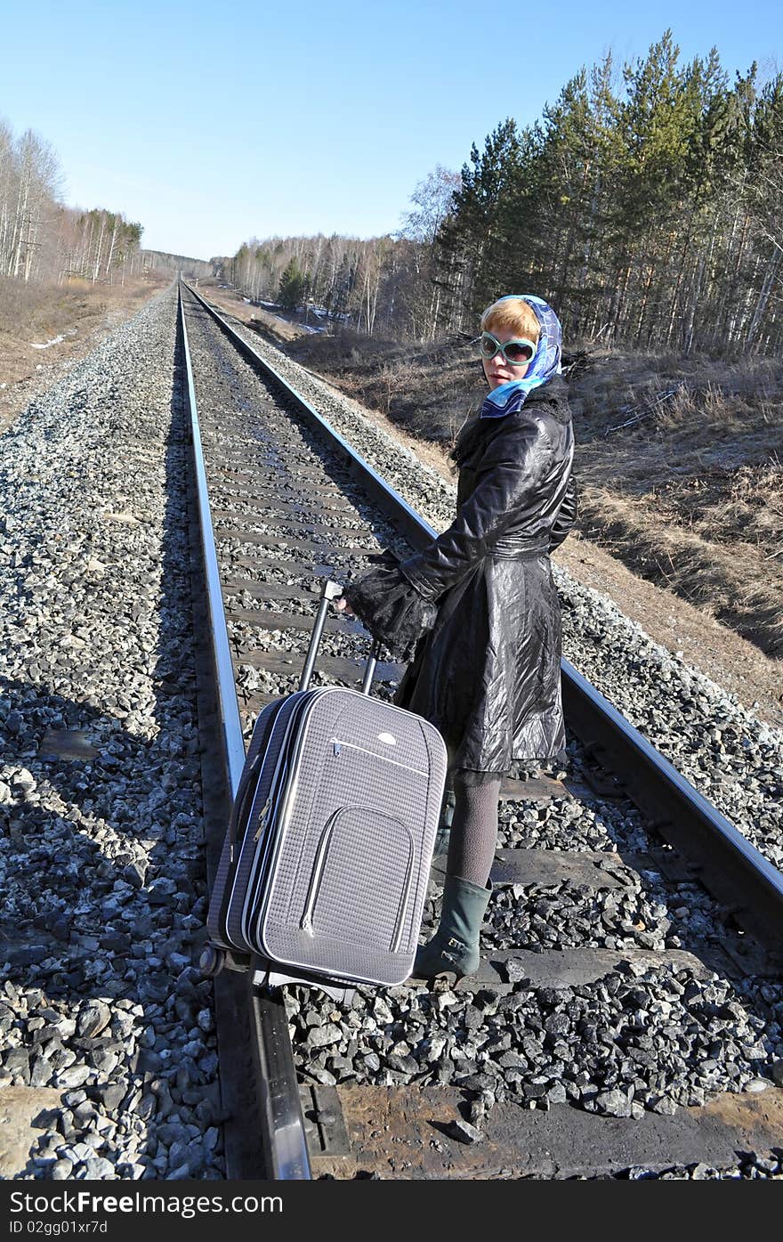 Woman in a scarf and sunglasses on the railroad. Woman in a scarf and sunglasses on the railroad