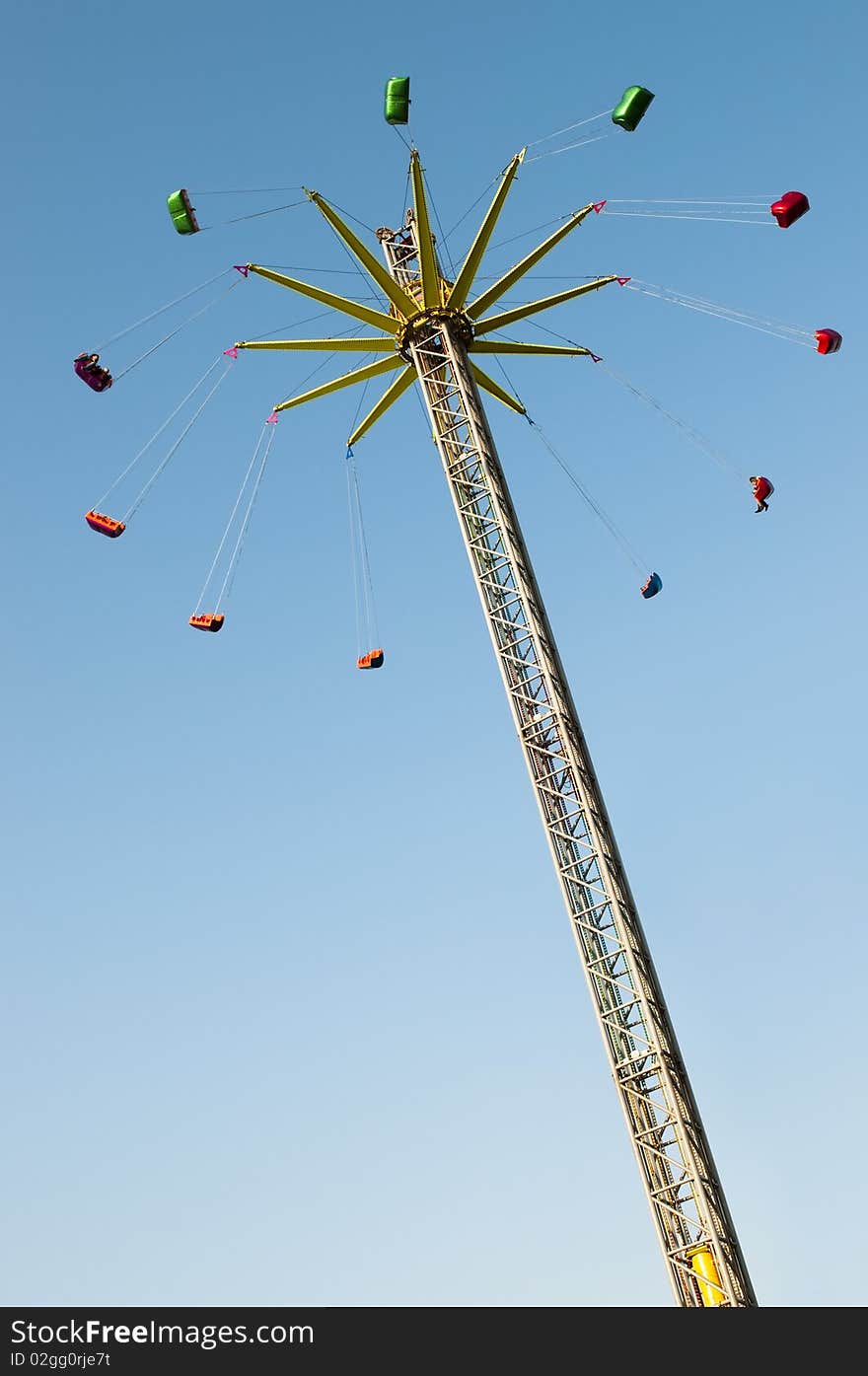 Modern lift chairoplane carousel on fun fair with blue sky