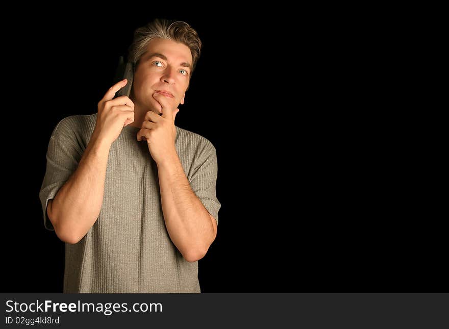 Man using a phone thinking on a black background