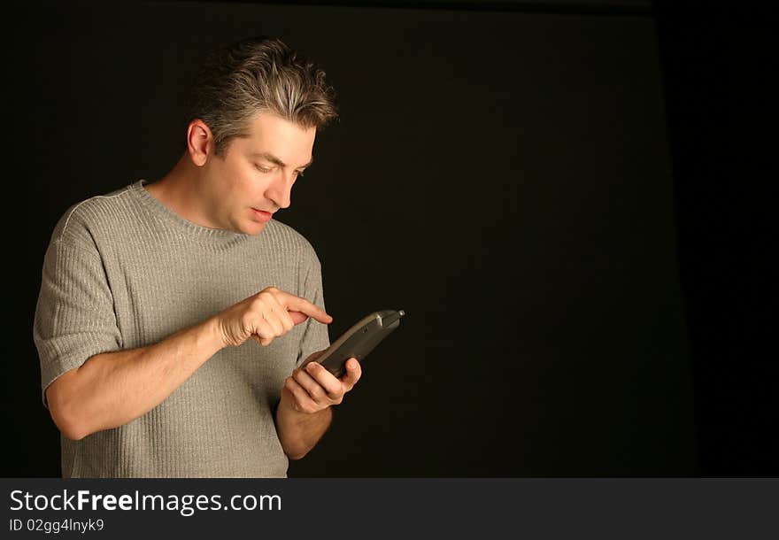 Man dialing a phone on a black background. Man dialing a phone on a black background