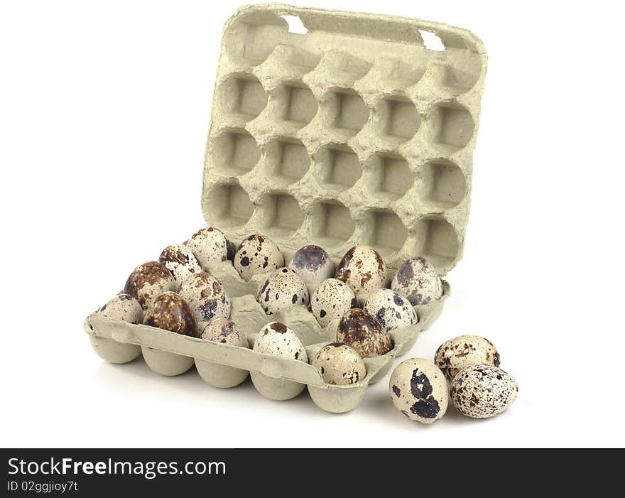 Quail eggs in a box on a white background