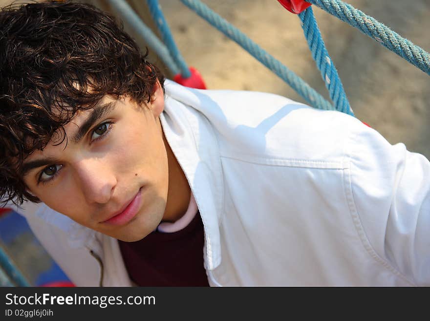 Young adult man in white, on a playground