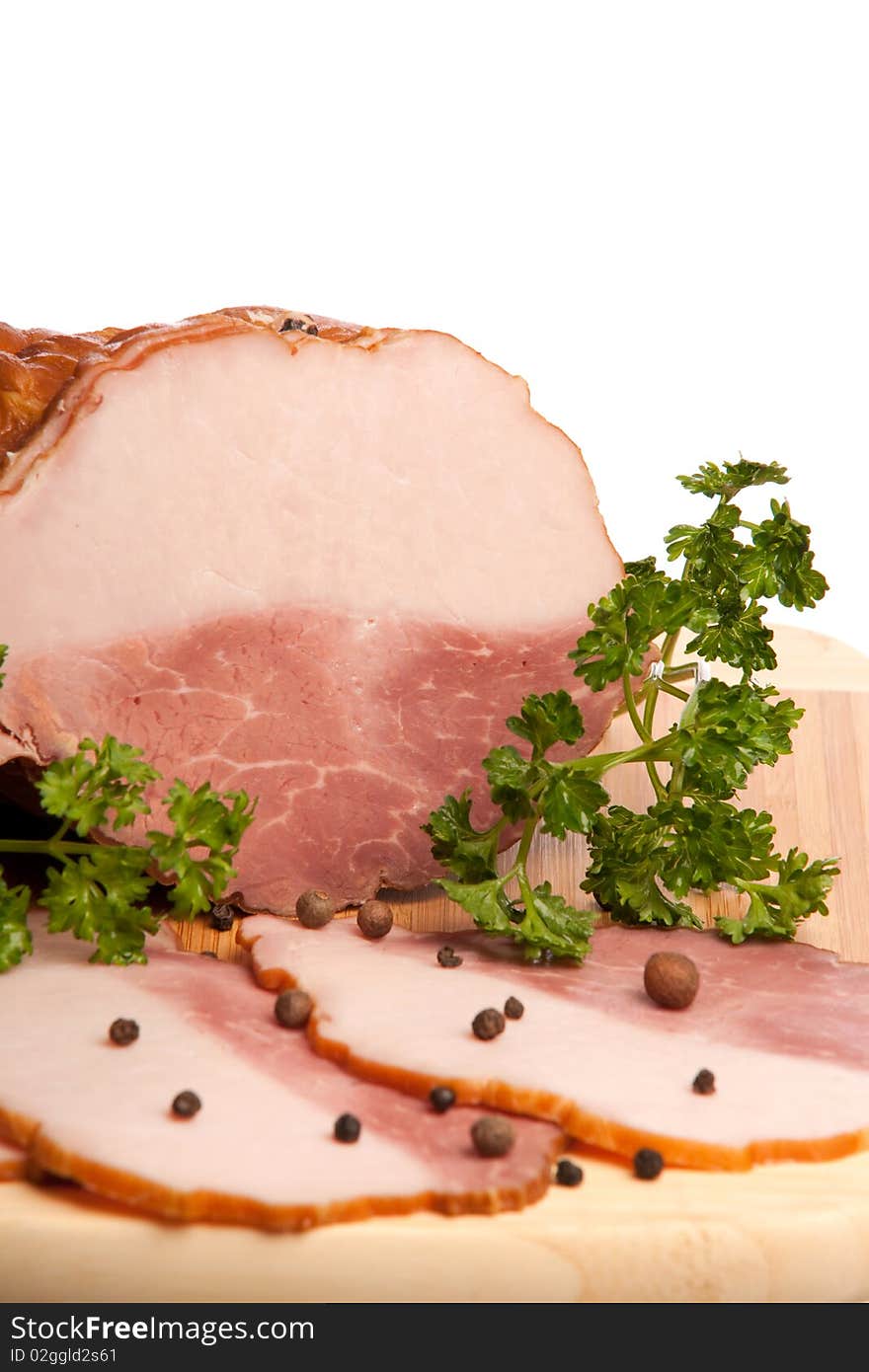 The boiled pork decorated by pepper and a parsley on a white background