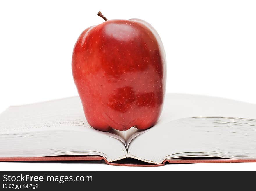 Red apple on the open book isolated over white