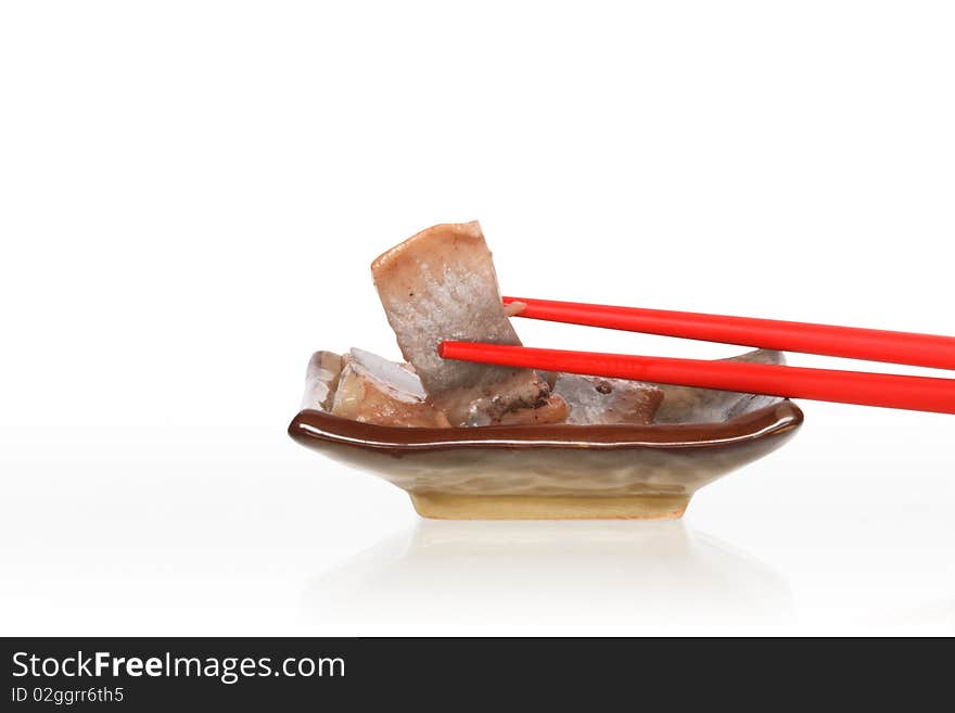 Pair of red chopsticks lying on plate with fish. Isolated on white with clipping path. Pair of red chopsticks lying on plate with fish. Isolated on white with clipping path