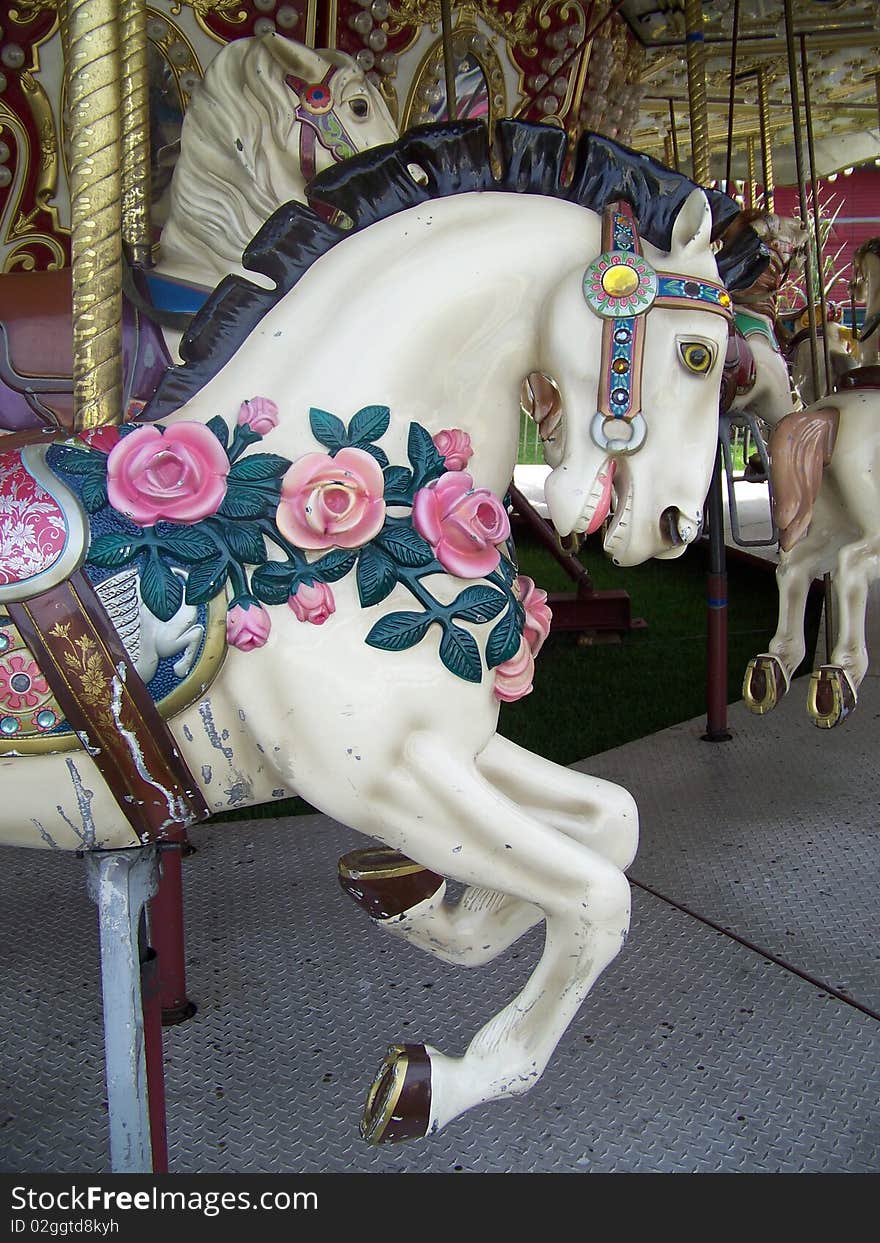 Ao old carousel horse is adorned with beautiful roses. Ao old carousel horse is adorned with beautiful roses