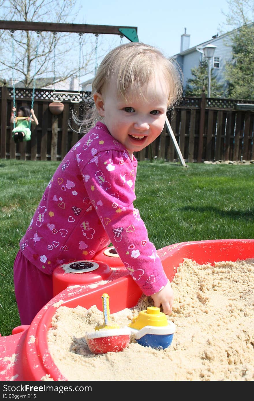 Little blonde baby in sandbox