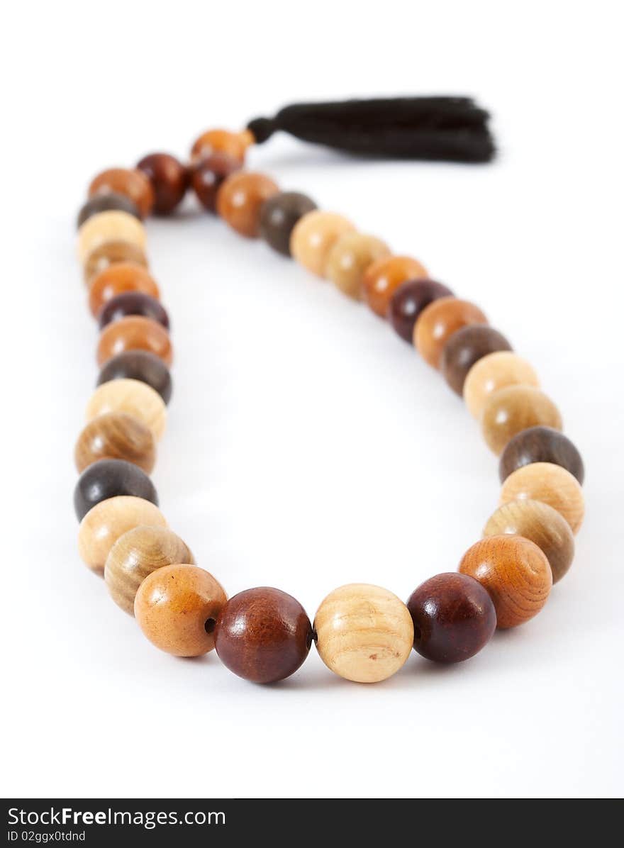 Wooden beads from various breeds of a tree on a white background. Wooden beads from various breeds of a tree on a white background.