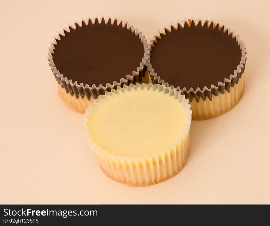 Homemade Cupcakes on a cream background. A cupcake is a small cake designed to serve one person, which may be baked in a small thin paper or aluminium cup. As with larger cakes, icing and other cake decorations such as fruit and candy may be applied. a small cake, the size of an individual portion, baked in a cup-shaped mould. Older Slang. A sexually attractive young woman. a beloved girl or woman. Noun. cupcake &#x28;plural cupcakes&#x29; A small cake baked in a paper container shaped like a cup, often with icing on top. &#x28;slang&#x29; An attractive young woman. &#x28;slang&#x29; A weak or effeminate man. Cupcakes are small, tasty snack cakes that are favoured for their portability and portion control. They are batter cakes baked in a cup-shaped foil or temperature resistant paper. A cupcake can be prepared from a variety of formulations and can be decorated with cream and icings. The mixing process and the consistency of the batter differentiate cupcakes and muffins. Cupcakes are made by creaming the butter and sugar together to create a smooth, fluffy batter.  Muffin batter, on the other hand, is beaten briefly and remains relatively lumpy. This makes for a more dense baked good.