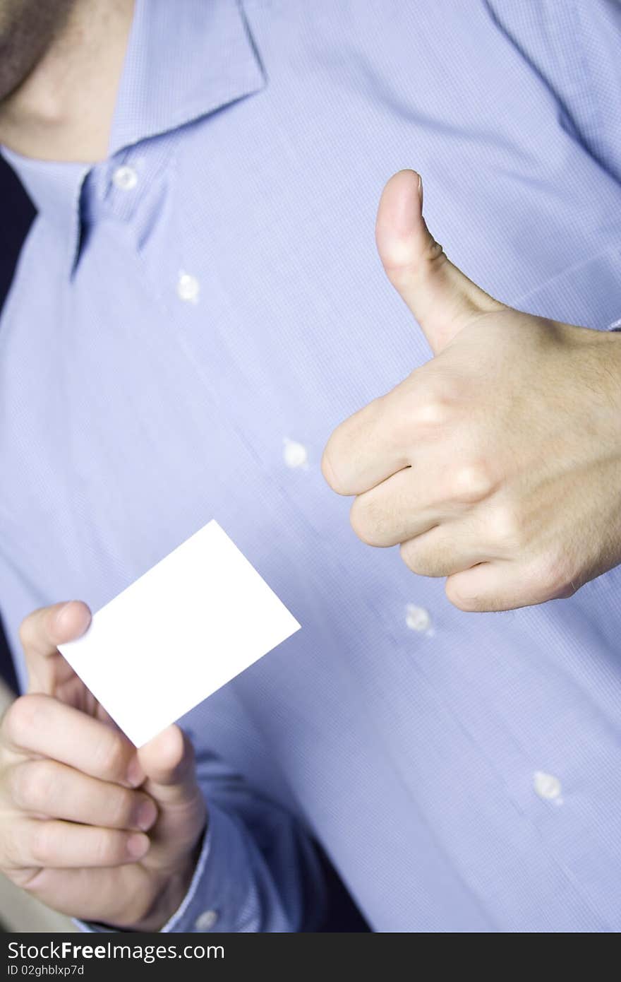 Business young man in a blue shirt holding a blank business card. Another hand the excitement thumb up. Business young man in a blue shirt holding a blank business card. Another hand the excitement thumb up