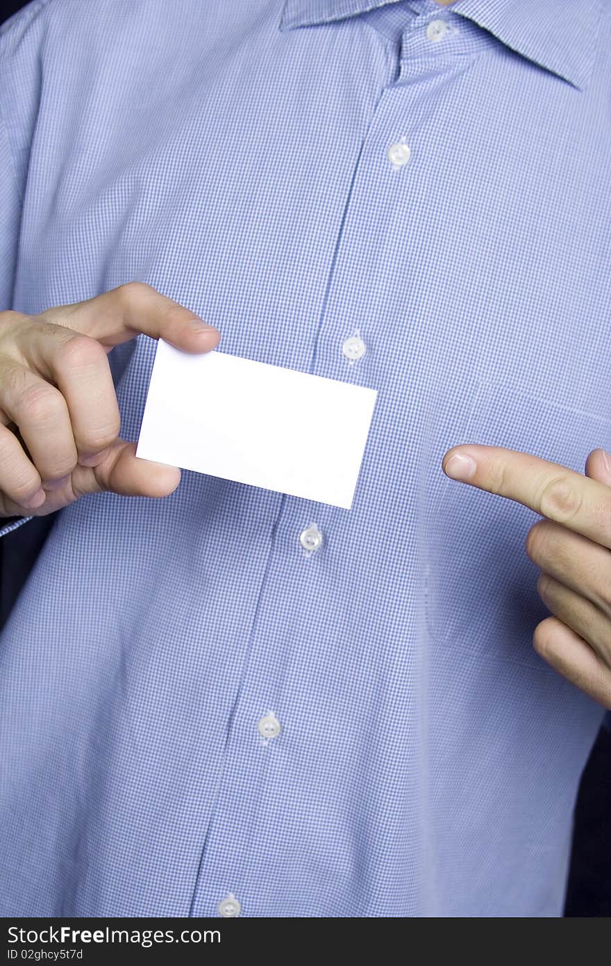 Business young man in a blue shirt holding a blank business card. The other hand points a finger. Business young man in a blue shirt holding a blank business card. The other hand points a finger