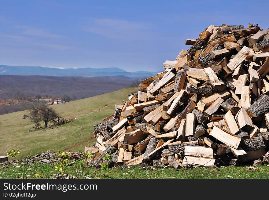 Woodpile on village panorama with blue sky