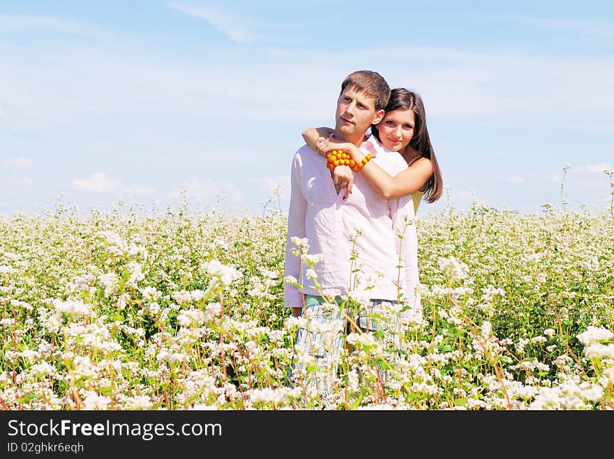 Young lovely couple in a spring field of flowers