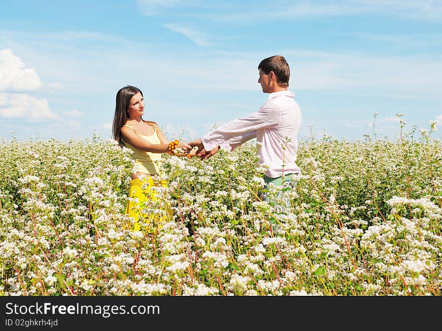 Young lovely couple in a spring field of flowers