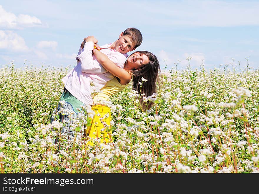 Young Lovely Couple On A Flower Field