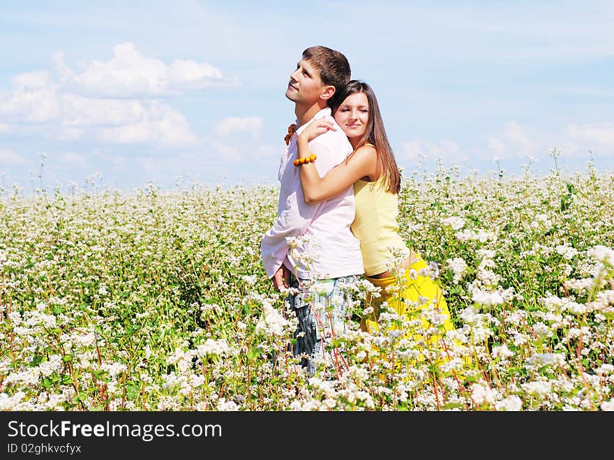 Young lovely couple on a flower field