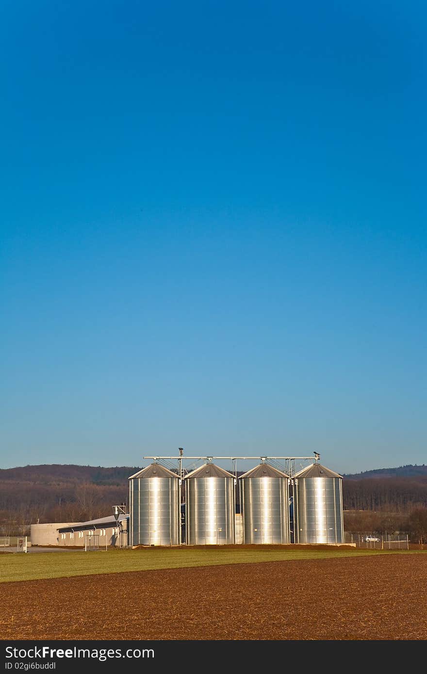 Beautiful landscape with silo and snow white acre with blue sky