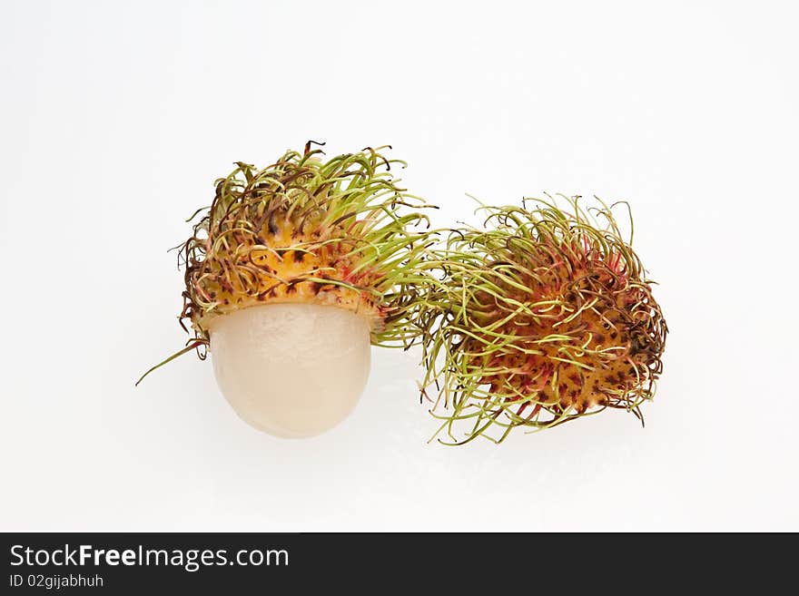 A halved rambutans against a white background