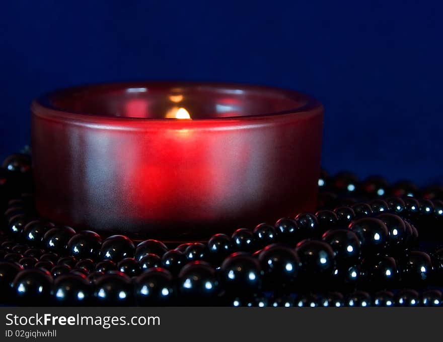 Red burning candle on a dark blue background