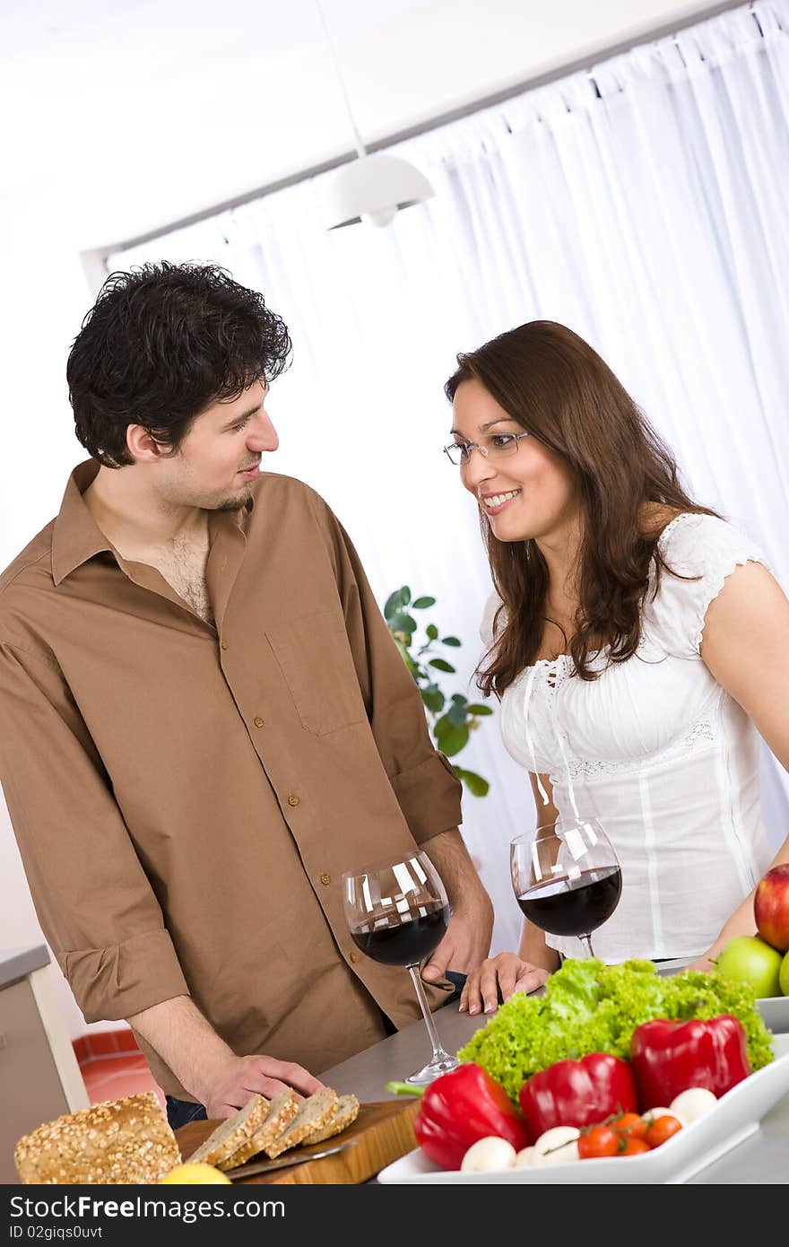 Happy couple drink red wine in modern kitchen