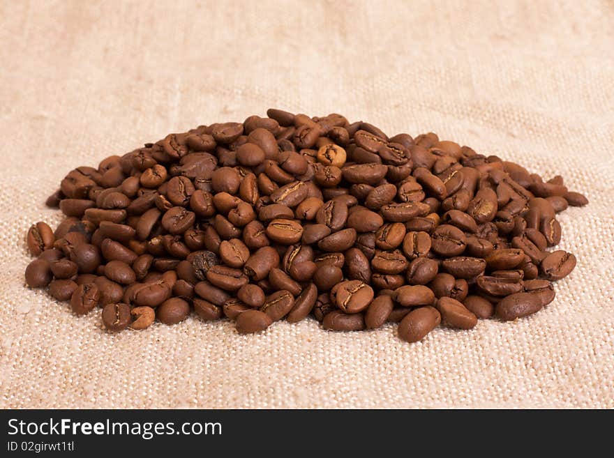 Heap of coffee beans on the rustic canvas