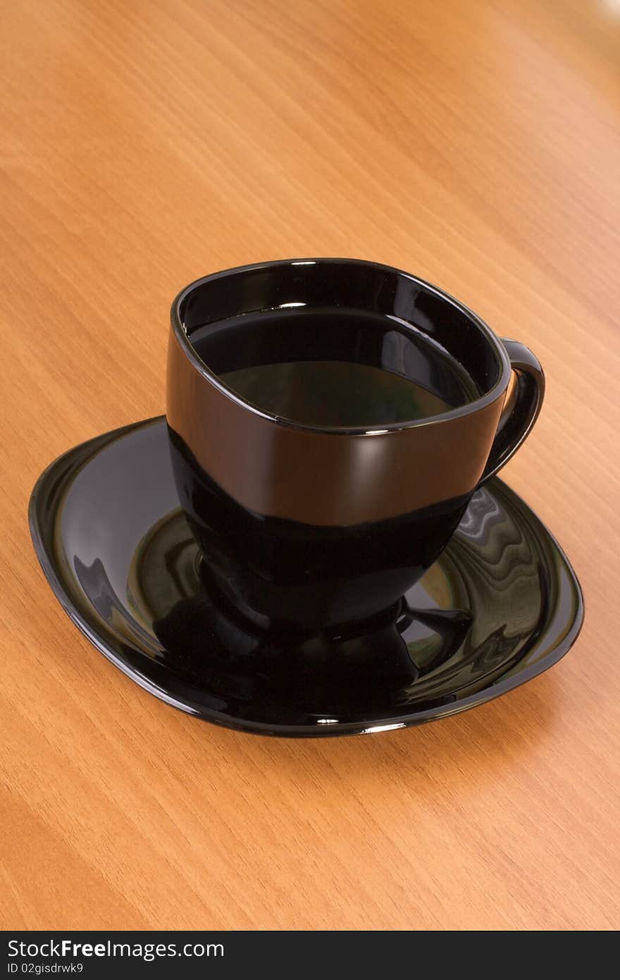 Black cup and plate on the wooden table. Black cup and plate on the wooden table