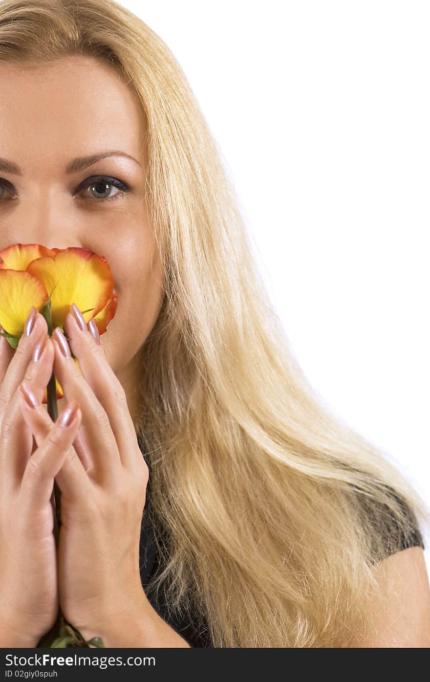 A beautiful woman breathing in the scent of a rose