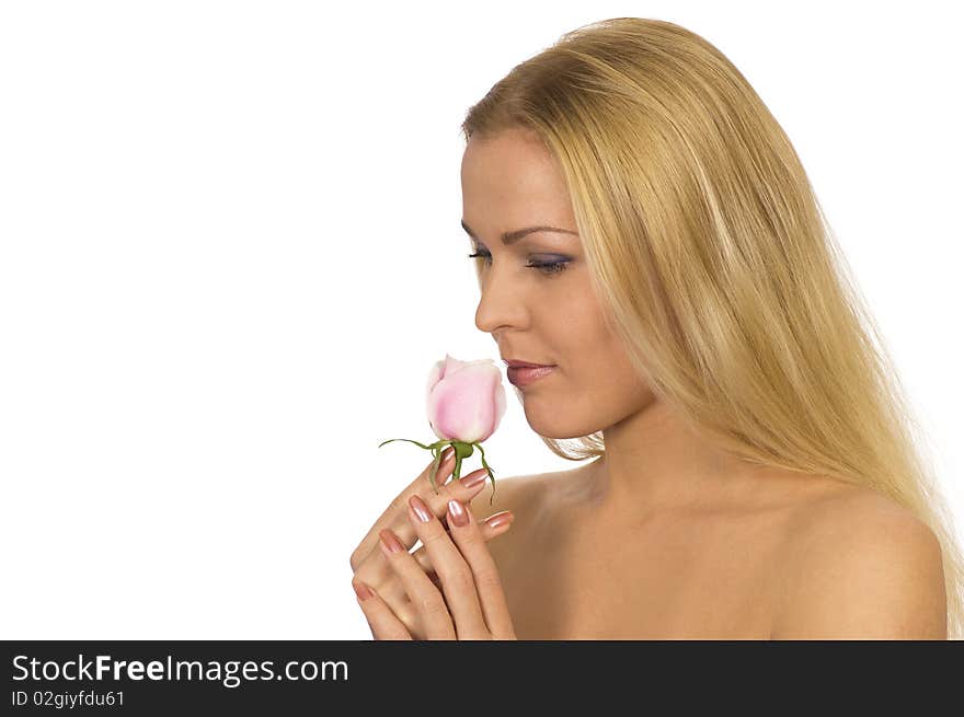 A beautiful woman breathing in the scent of a rose