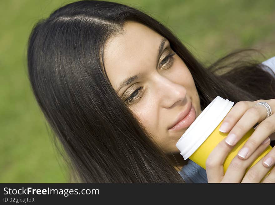 Beautiful girl sunny day in the park drinking coffee from paper cups. Portrait. Beautiful girl sunny day in the park drinking coffee from paper cups. Portrait