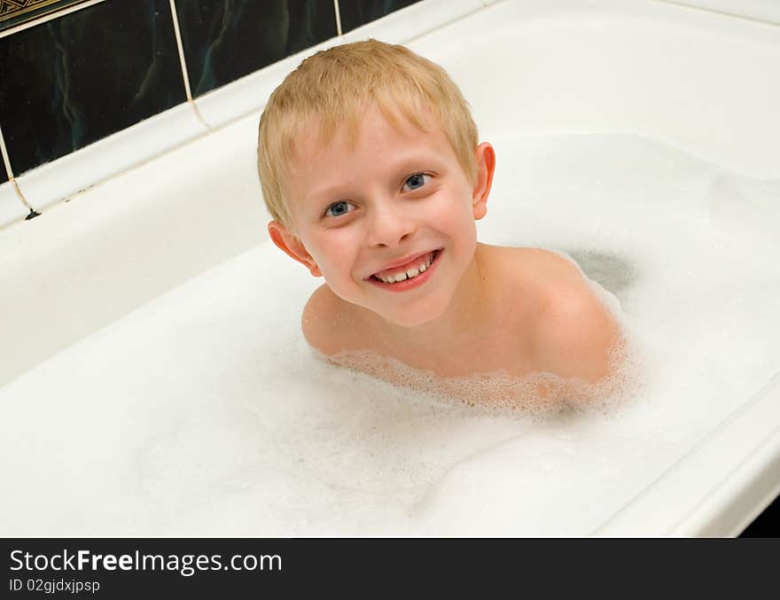 The boy bathes in a bathroom