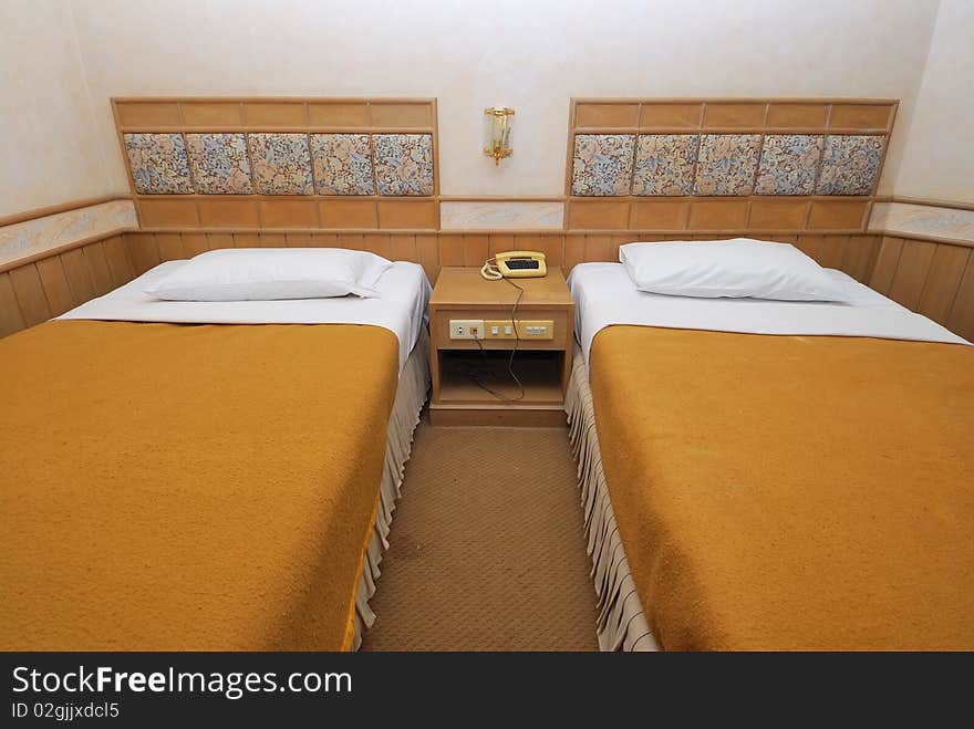 Twin beds neatly done up in a high class hotel room. Suitable for concepts such as travel, tourism, vacation and holiday. Twin beds neatly done up in a high class hotel room. Suitable for concepts such as travel, tourism, vacation and holiday.