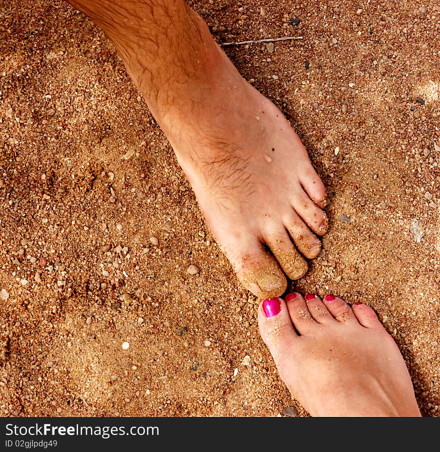 Man and woman feet on sandy beach. Man and woman feet on sandy beach