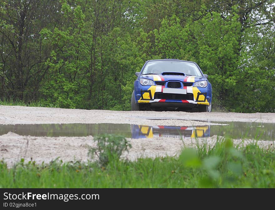 Blue race rally car on dirt road competition