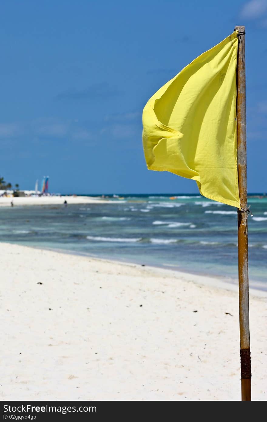 Yellow flag on white sand beach in tropics. Yellow flag on white sand beach in tropics